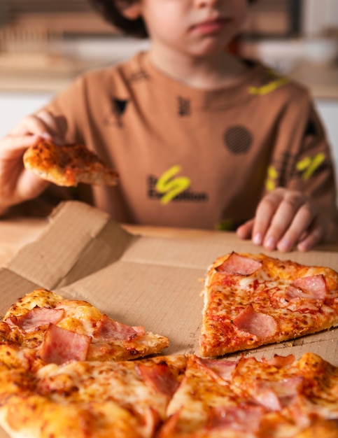 Criança comendo pizza em casa