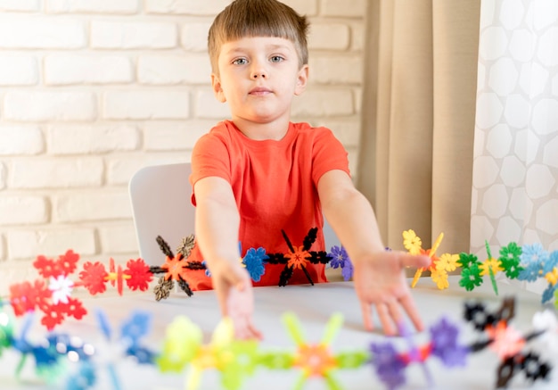 Foto grátis criança de tiro médio com brinquedo floral