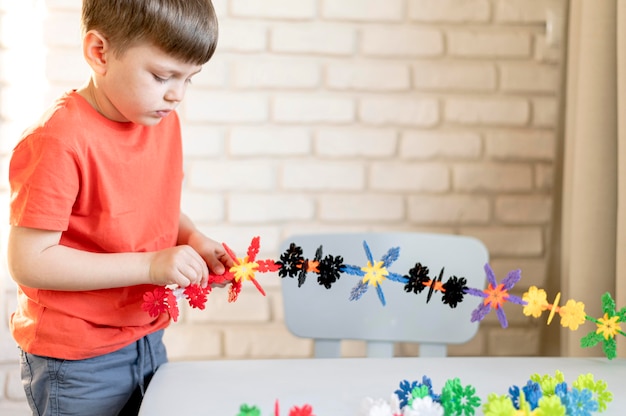 Criança de tiro médio com brinquedo floral