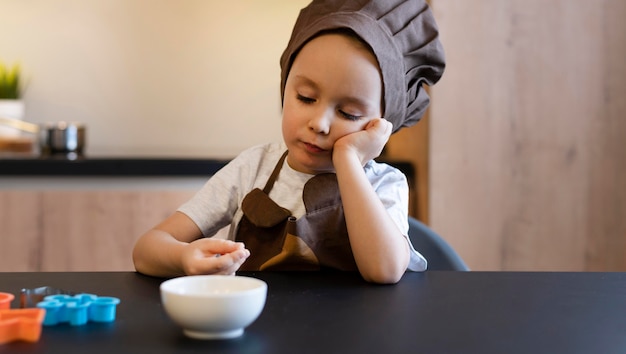 Foto grátis criança de tiro médio sentado à mesa