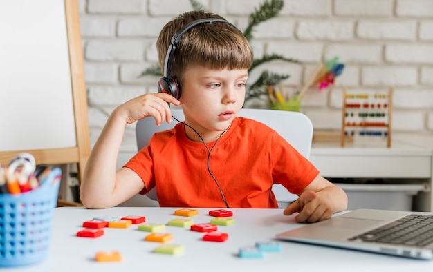 Criança de tiro médio usando fones de ouvido