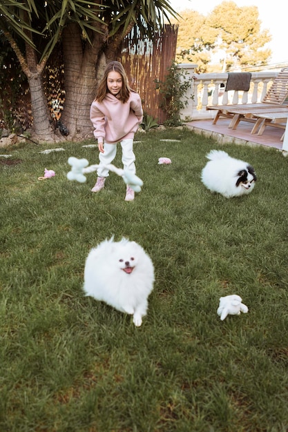 Criança do sexo feminino e cachorro fofinho brincando