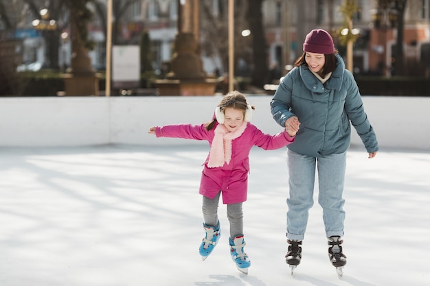 Criança e mãe patinando juntos