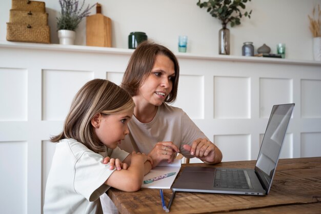 Criança e mulher de tiro médio com laptop