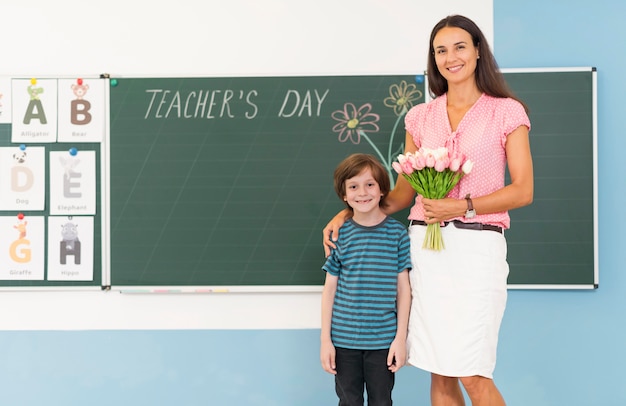 Criança e professora segurando um buquê de flores com espaço de cópia