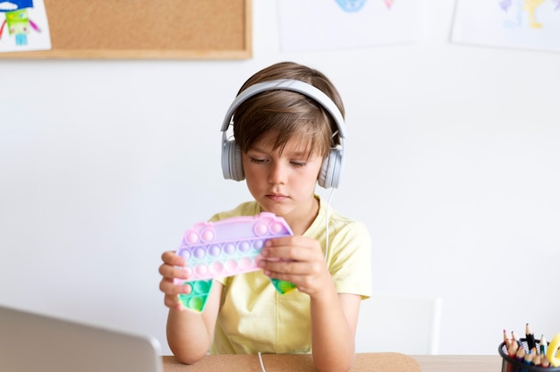 Criança em tiro médio usando fones de ouvido