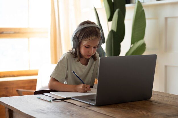 Criança estudando em casa tiro médio