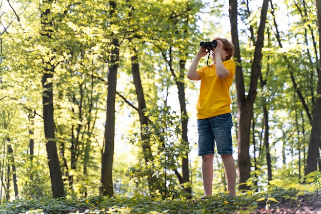 Criança explorando a floresta no dia do meio ambiente