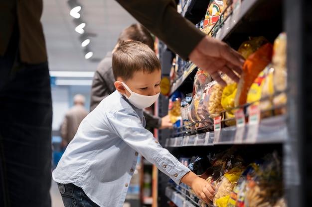 Criança fazendo compras com máscara facial