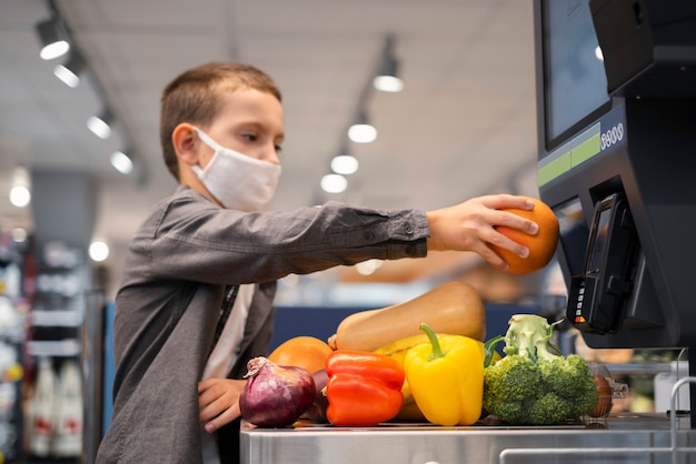 Criança fazendo compras com máscara facial