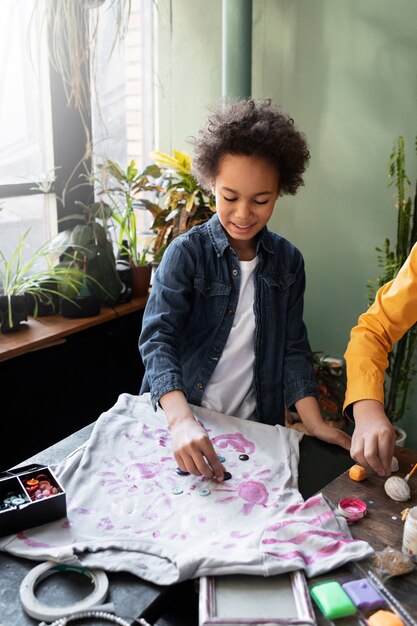 Criança fazendo projeto diy a partir de materiais reciclados