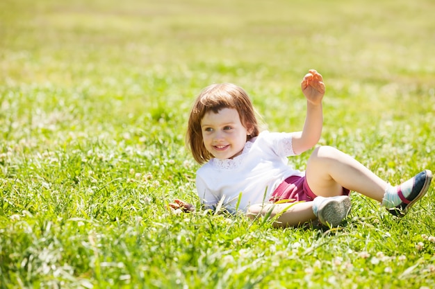 Criança feliz brincando no prado da grama