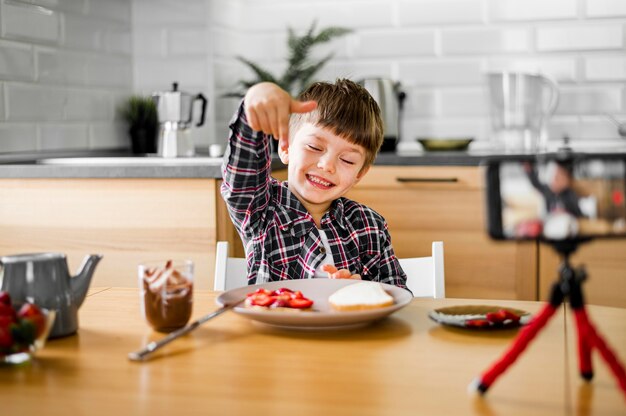 Criança feliz com telefone e comida