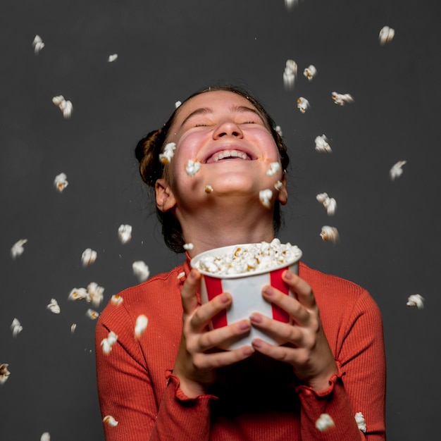 Criança feliz com tiro médio segurando pipoca