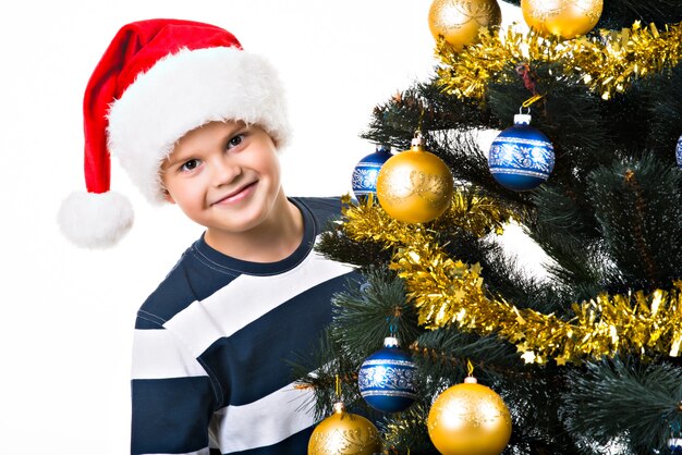 Criança feliz com um presente perto da árvore de Natal