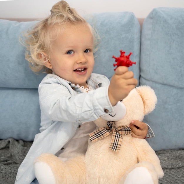 Criança fofa com brinquedo em casa durante a quarentena