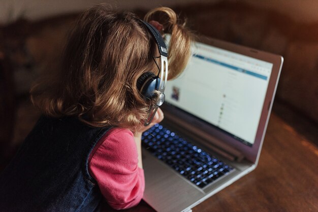 Criança linda feliz em fones de ouvido, ouvindo música