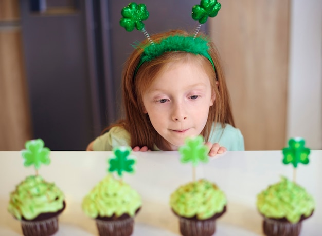 Foto grátis criança olhando para deliciosos cupcakes