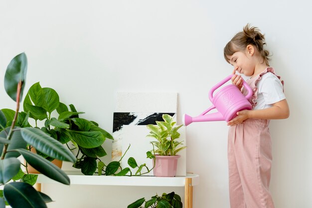 Criança regando plantas em casa