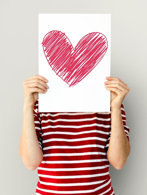 criança segurando um ícone de coração em um papel
