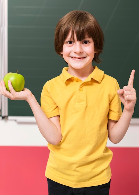 Criança segurando uma maçã verde