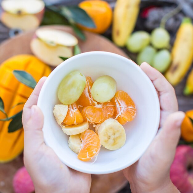 Criança segurando uma tigela de frutas