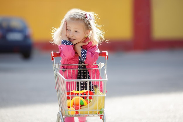 Criança sorridente feliz comprando criança com carrinho