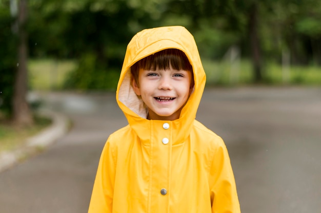 Criança sorrindo no casaco de chuva