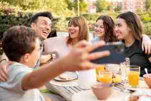 Foto grátis criança tirando selfie de família almoçando ao ar livre juntos