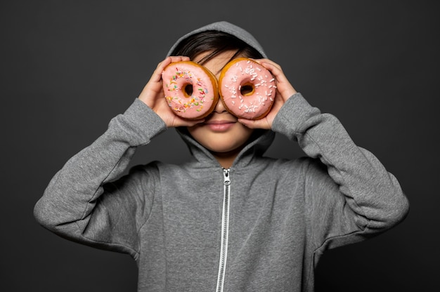 Criança tiro médio segurando rosquinhas