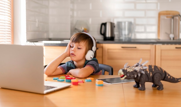 Criança usando fones de ouvido na escola online