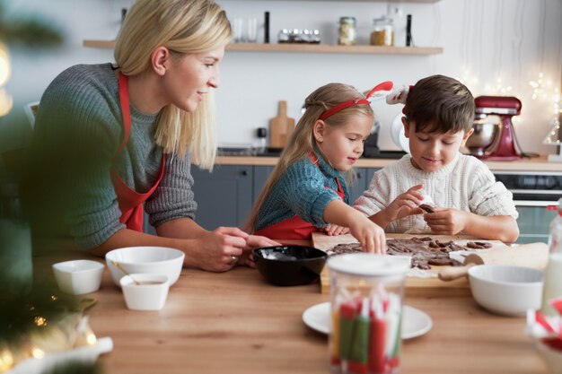 Crianças assando biscoitos de gengibre em cozinha doméstica