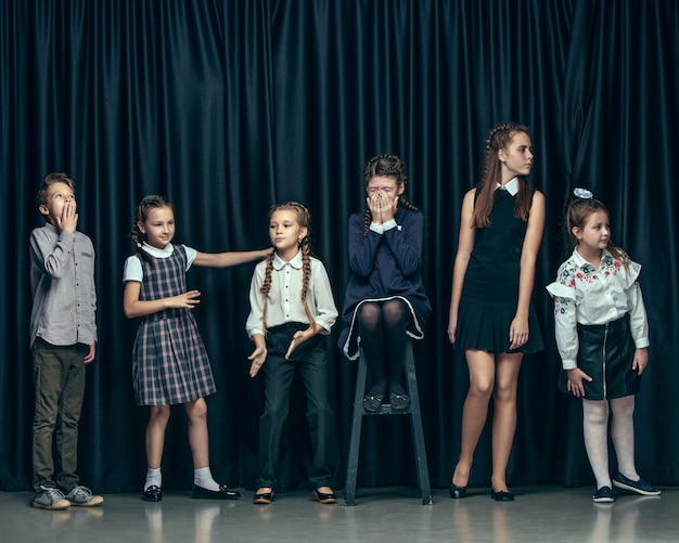 Foto grátis crianças bonitos e elegantes no espaço escuro. as lindas meninas adolescentes e meninos juntos