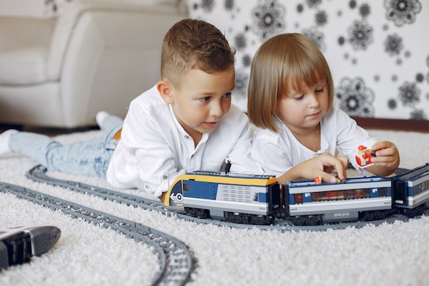 Crianças brincando com trem de lego e brinquedo em uma sala de jogos