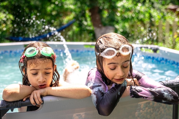 Crianças brincando na piscina doméstica no verão