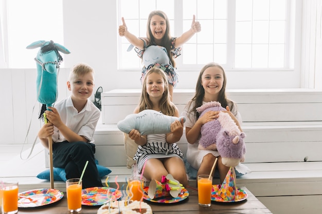 Crianças, com, brinquedos, olhando câmera, durante, partido aniversário