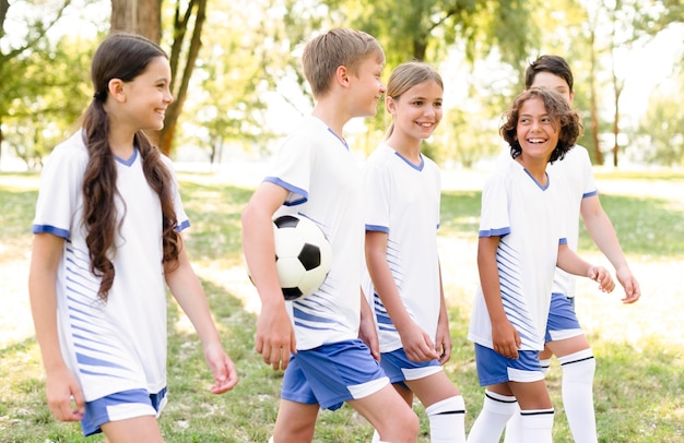 Crianças com equipamento de futebol se preparando para uma partida