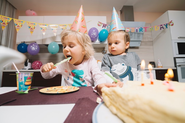 Crianças comendo bolo na festa de aniversário