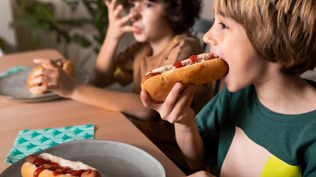 Crianças comendo cachorro-quente juntas