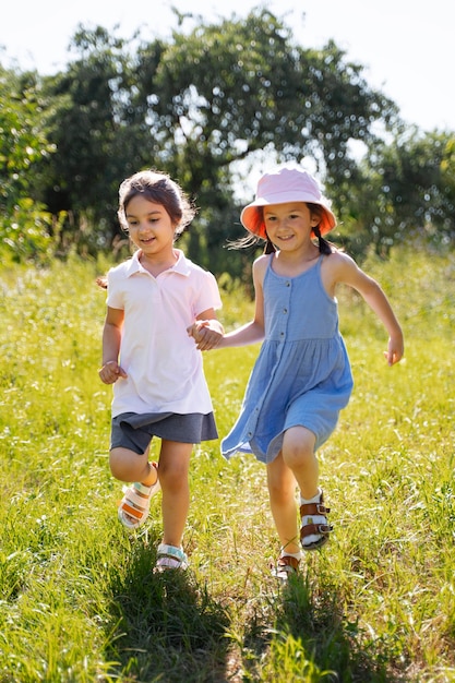 Foto grátis crianças correndo e brincando no campo de grama ao ar livre