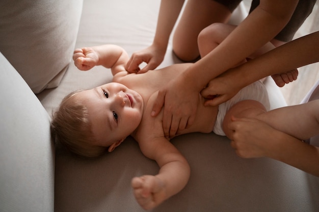 Crianças de alto ângulo fazendo cócegas em bebê