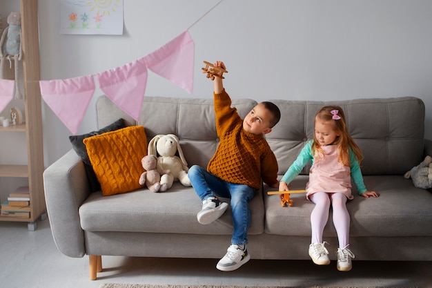 Foto grátis crianças de tiro completo brincando em casa