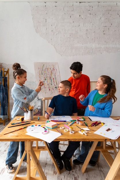 Foto grátis crianças de tiro completo pintando na escola