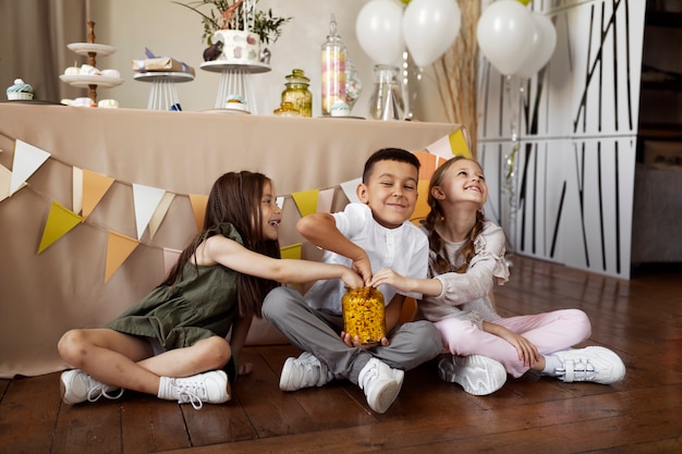 Foto grátis crianças de tiro completo se divertindo na festa