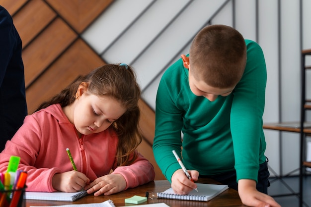 Foto grátis crianças de tiro médio aprendendo na escola