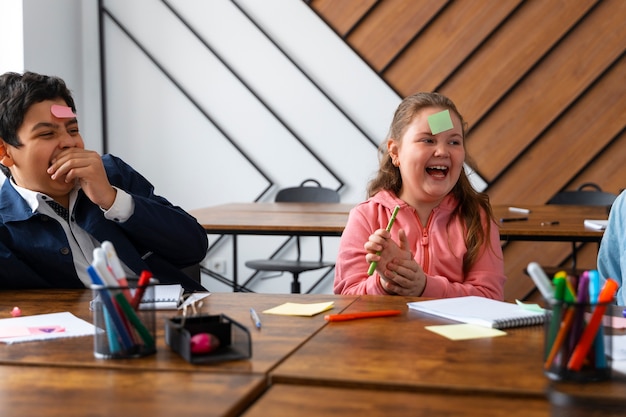 Crianças de tiro médio aprendendo na escola