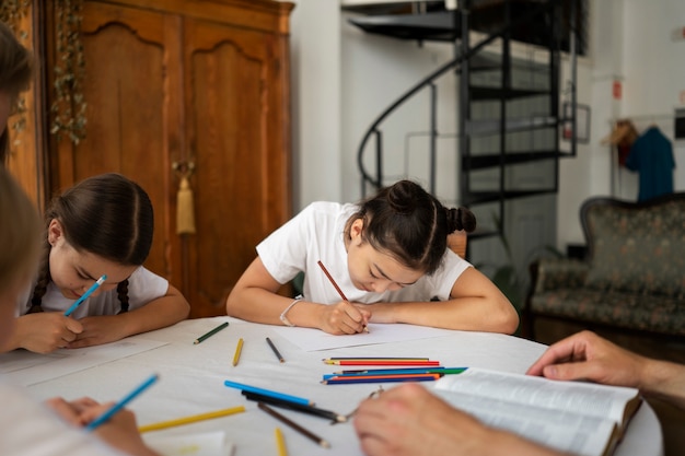 Foto grátis crianças de tiro médio desenhando na escola