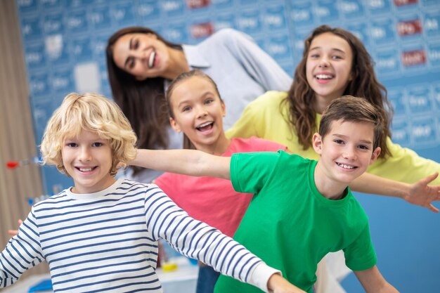 Crianças e professores de humor brincalhão sorrindo para a câmera