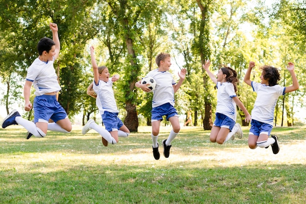 Crianças em roupas esportivas pulando ao ar livre