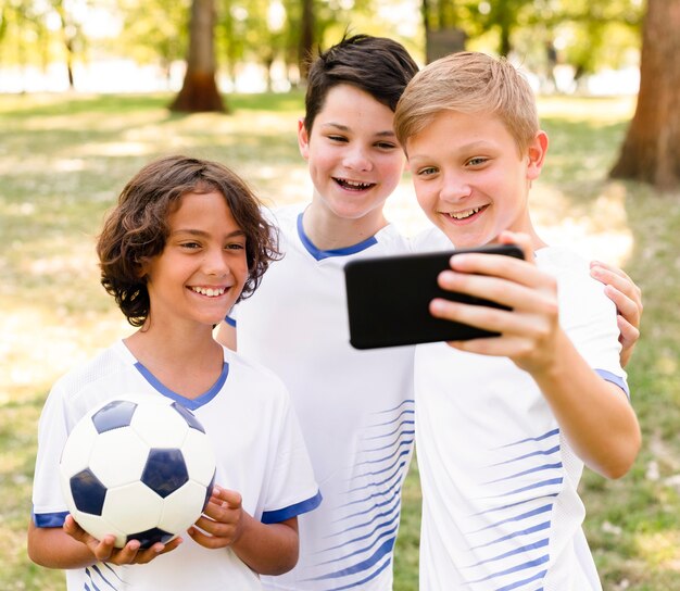 Crianças em roupas esportivas tirando uma selfie